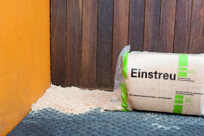 Zuletzt das Einstreu auf dem Boden der Pferdebox aufbringen.